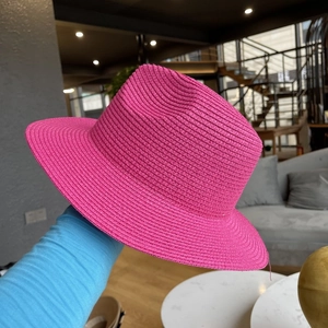 Detail of hand-woven straw jazz hat in vibrant rose red showing fine texture