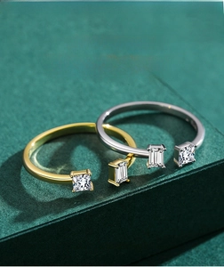 Detail of silver and gold open rings with rectangular cut simulated diamonds on display