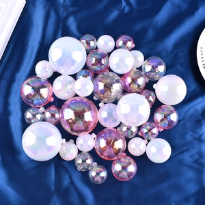 Colorful mix of iridescent pink-purple and pearl white sphere cake toppers on blue satin
