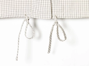 Detailed view of the plaid nylon jacket fabric featuring white and black grid patterns