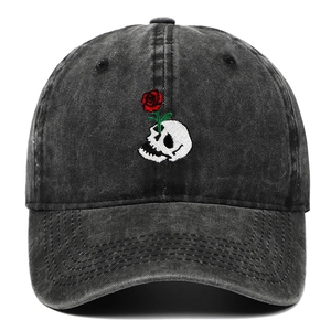 Faded black baseball cap with embroidered skull and red rose motif in retro street style