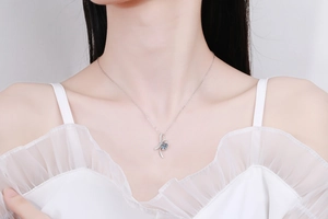 Close-up of s925 silver necklace featuring a bow-shaped pendant with a 1ct blue moissanite stone