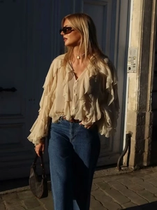 Chic beige ruffle long sleeve V-neck blouse paired with blue jeans for casual wear