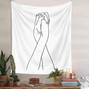 Detail of minimalist line art tapestry showing interlocking hands hanging in a cozy room