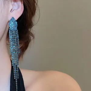 Sparkling silver needle jellyfish tassel earrings with blue rhinestones on a female model