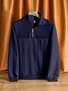 Dettaglio maglione in maglia blu scuro con motivi geometrici e colletto con mezza zip