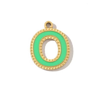 Detailed view of golden letter O pendant with green enamel and beaded edge texture