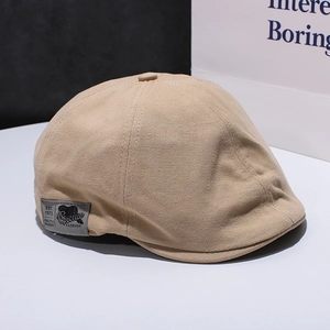 Detail der khakifarbenen Schiebermütze mit Vintage-Patch und Stickerei EST. 1973