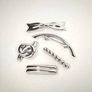 Detail of 5-piece silver metal hair clip set featuring bow and twist knot designs