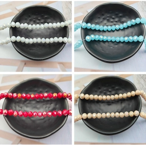 Close-up of faceted crystal glass beads with AB coating in white, blue, red and beige