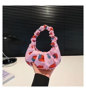 Dettaglio della borsa a spalla rosa con stampa fragola e manico arricciato in nylon