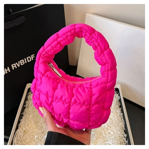 Close-up of vibrant rose pink quilted mini bag with silver metal zipper and soft texture