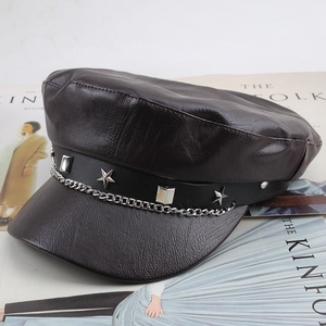Detail of dark brown leather newsboy cap with silver metal chain and star stud ornaments