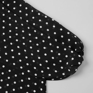 Détail du haut en mousseline noire à pois blancs avec poignet élastique plissé et transparent