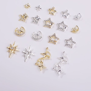 Macro detail of gold and silver alloy star and moon nail charms with rhinestones and pearls