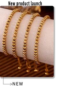 Detail of four luxurious 4mm gold beaded bracelets on a professional display stand