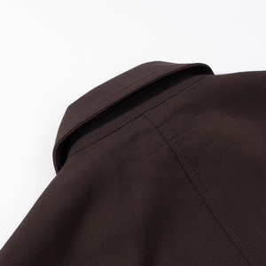 Deep brown cotton jacket featuring reinforced stitching and premium canvas fabric texture
