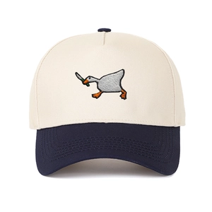Detailed embroidery of a goose holding a knife on a navy and cream panel baseball cap