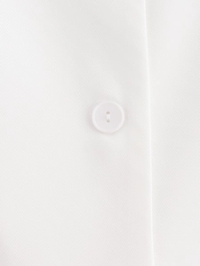 Close-up detail of a white V-neck vest featuring a round button and twill fabric texture