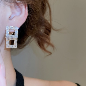 Close-up of 18K gold plated hollow rectangular earrings with sparkling zircon stones