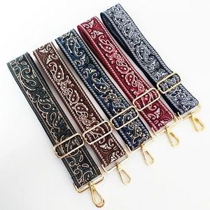 Five colorful paisley embroidered purse straps with golden metal hooks on white background