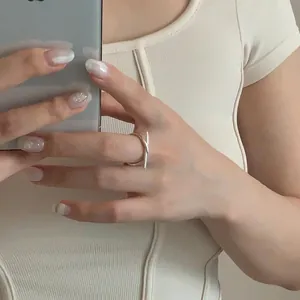 Detail of minimalist 925 sterling silver knotted ring shown on model in a mirror selfie