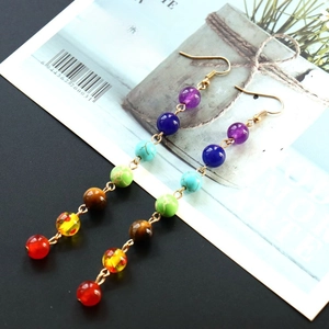 Detail of colorful chakra gemstone bead drop earrings with natural stone and golden hooks