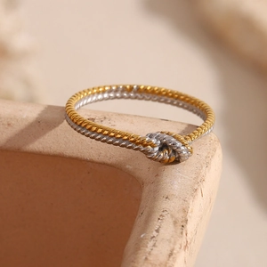 Macro shot of two-tone twisted rope ring detail with 18K gold and silver textures