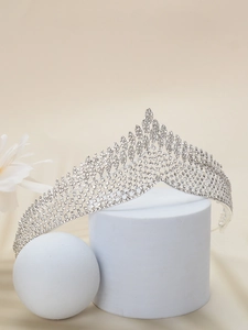 Close-up of silver bridal crown featuring intricate rhinestone inlay on display stand