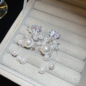 Macro di orecchini a nappa con perle in argento e zircone a cuore in un portagioie di velluto
