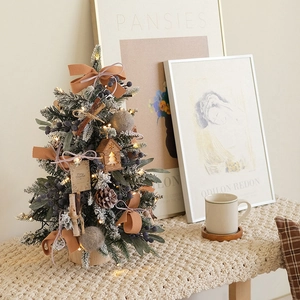 Mini Christmas tree with orange ribbons, pine cones, and LED lights on a wood base