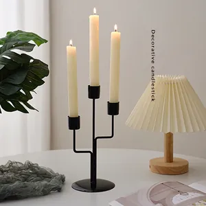 Three-arm black iron decorative candlestick with white candles for table centerpieces