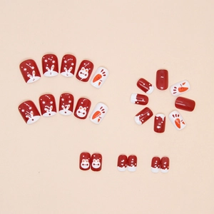 Close-up of wine red fake nails with cute white rabbit and carrot patterns for New Year