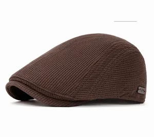 Détails de la casquette plate café en tricot montrant la texture tissée en sergé