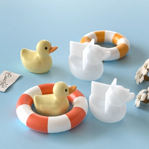 Close-up of duck and lifebuoy silicone molds with finished resin crafts on blue background