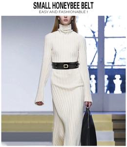 Model wearing a black PU wide waist belt with a gold square buckle over a white dress