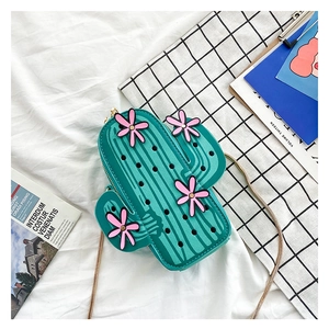 Close-up of green cactus-shaped crossbody bag with pink flowers and gold chain strap