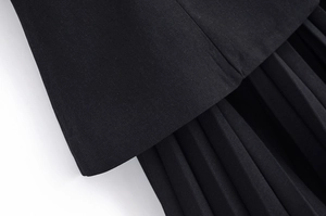 Détail des plis nets sur le tissu noir tissé de la robe sans manches à col en V