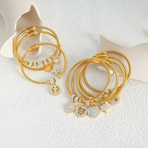 Bracciale a serpente multistrato dorato con ciondoli in strass e chiusura magnetica