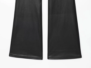 Close-up detail of the hem stitching and texture on black faux leather flared pants