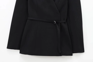 Detailed view of black slim-fit blazer with metallic buckle belt and fabric texture