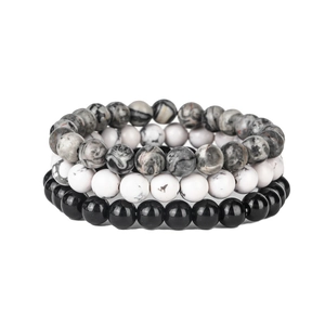 Close-up of 8mm rose quartz and black onyx beaded yoga bracelets in a set of three