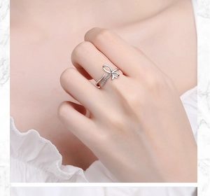 Detail of silver bow ring with shimmering crystals on a model's finger