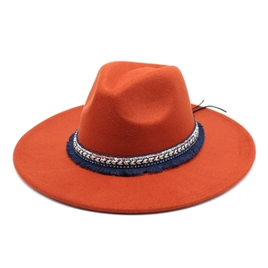 Detail of orange wool felt fedora with ethnic style embroidered band and blue fringes