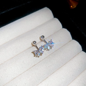 Macro shot of silver bow stud earrings with zircon stones and shimmering starburst effect
