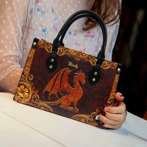 Close-up of vintage leather handbag featuring dragon embossing and custom gold Wendy text