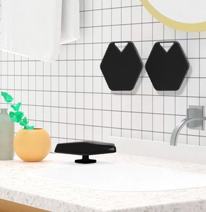Close-up of black hexagonal silicone brush with suction handle on white tile