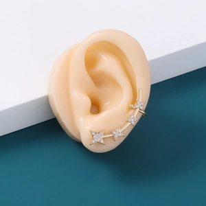 Detail of a gold star ear cuff with clear crystals on a realistic ear model display
