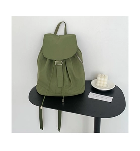 Dettaglio dello zaino in nylon verde militare con chiusura a coulisse e hardware metallico