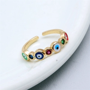 Macro view of adjustable gold-plated ring featuring multi-colored evil eye enamel inlay